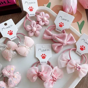 Detailed close-up of pink fabric bow hair ties and floral elastic bands for girls