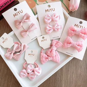 Set di fiocchi per capelli rosa con pois e motivi a quadri su schede display