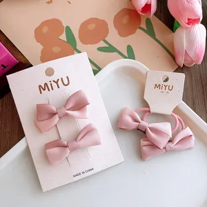 Set di fermagli e elastici per capelli con fiocchi in tessuto rosa per bambine in dettaglio