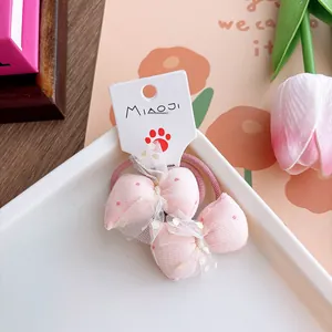Pink polka dot bow hair ties with gold glitter mesh on a decorative display card