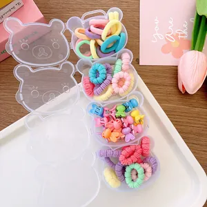 Close-up of four bear-shaped boxes with macaron colored hair ties and mini hair clips