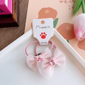 Detail of pink bow hair ties with crystal accents on a white display card