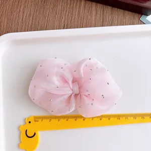 Detail of pink organza bow hair clip with silver rhinestones, measuring about 10cm wide