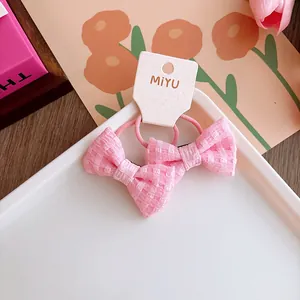 Coppia di elastici per capelli rosa a quadretti per bambina su cartoncino bianco