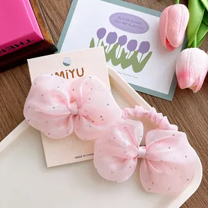 Pink seersucker bow hair clip and elastic band set with silver glitters on white tray