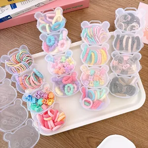 Flat lay of colorful hair ties and clips in cute bear-shaped transparent boxes