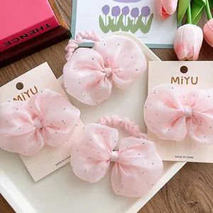 Close-up of pink seersucker bow hair clips with silver rhinestones on display card