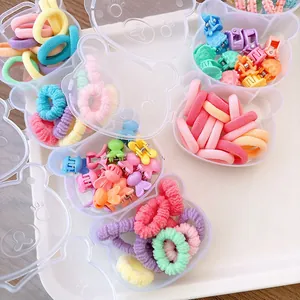 Close-up of colorful kids hair ties and clips in cute bear-shaped storage boxes