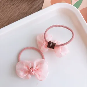 Detailed macro of pink bow hair ties with heart prints on transparent organza fabric