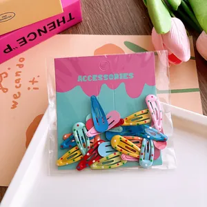 Close-up of colorful polka dot and solid snap hair clips in retail packaging on a bright tray
