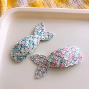 Close-up of glitter sequins fish tail hair clips for girls on a beige tray display