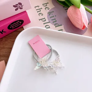 Detail van holografische vlinder haarelastiekjes op een roze presentatiekaart