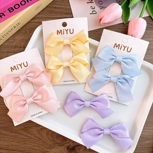 Detail view of colorful satin bow hair clips on display card with tulip decoration
