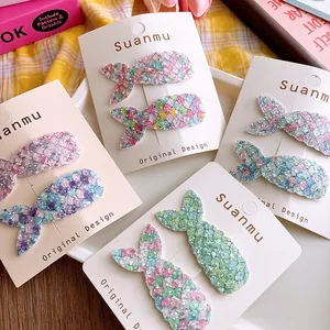 Close-up of glittery mermaid tail hair clips with colorful sequins on display card