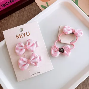Dettaglio di fiocchi rosa a pois con fermagli ed elastici con etichette fatte a mano