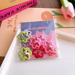 Macro detail of multi-colored hollow flower hair clips in various vibrant spray-painted colors