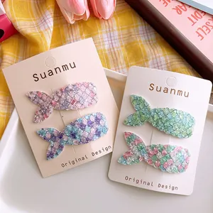Close-up of sparkling mermaid tail hair clips with glitter scales on a display card