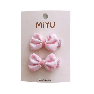 Set di fermagli per capelli con fiocchi rosa a pois per bambine su carta regalo