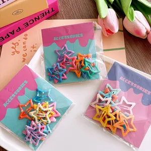 Close-up of colorful star-shaped hair clips in packaging with pink decorative accents