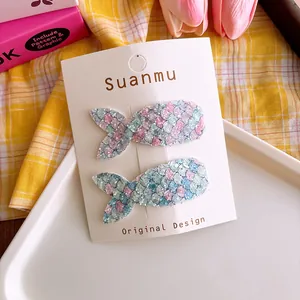 Detail of glitter fishtail hair clips for girls featuring colorful sequins on a display card
