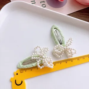 Lot de deux barrettes à cheveux vert clair avec perles et règle pour l'échelle