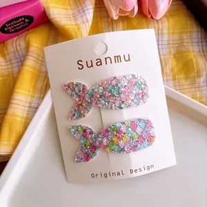 Detail of glitter mermaid tail hair clips with colorful sequins on a display card