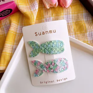 Detail of sequined mermaid tail hair clips for girls on a white display card