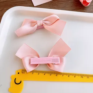 Set of two pink satin bow hair clips for girls with fabric-wrapped alligator clips