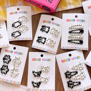 Close-up of handmade black and white polka dot hair clips in various geometric shapes