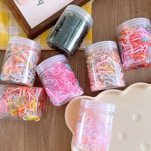 Jar of 200 high-elastic colorful hair ties for girls on a rustic wooden table setting