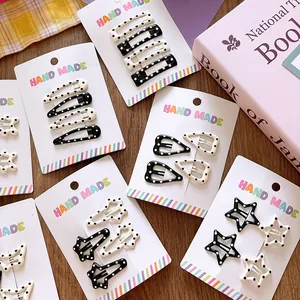 Close-up of black and white polka dot hair clips in star and heart shapes for girls