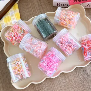 Eight jars of colorful elastic hair bands on a decorative tray for kids styling