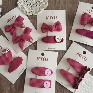 Vista piatta di fiocchi rosa e forcine a cuore su cartoncino con marchio