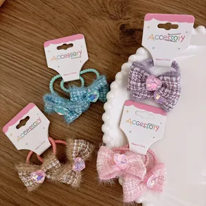 Set of four tweed bow hair ties with heart gems in blue, purple, brown, and pink