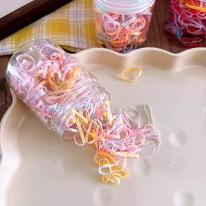 Detail of colorful elastic hair bands for kids in a clear jar on a stylish tray