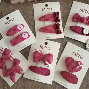 Dettaglio di fermagli per capelli con fiocco rosa e forcine a cuore su carta espositiva