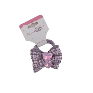 Sweet purple tweed bow hair tie for girls featuring pink crystal heart accents on a card