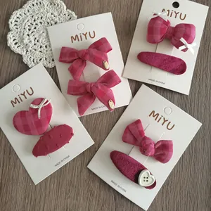 Set di fermagli per capelli rosa con fiocchi e motivi a scacchi su carta