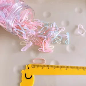 Macro view of colorful elastic hair bands with a cute pig ruler for size reference