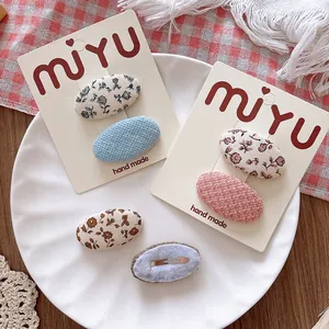 Handmade floral fabric BB hair clips for girls set on a decorative ceramic plate