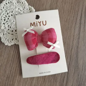 Set dettagliato di fermaglio a fiocco rosa a quadri e clip in tessuto su cartoncino
