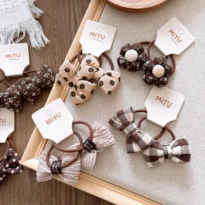 Lot d'élastiques à cheveux avec fleurs, pois et carreaux sur carte présentoir