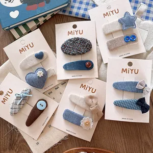 Detail of blue fabric hair clips with heart and floral patterns on card display