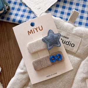 Detail of blue fabric star hair clips and button hair pins on a white display card