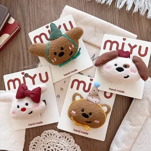 Flat lay of handmade plush cartoon animal hair clips on a rustic wooden background