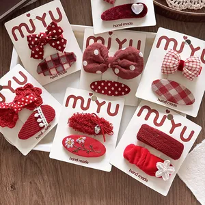 Close-up of red fabric hair clips with bows and embroidery in a set for girls