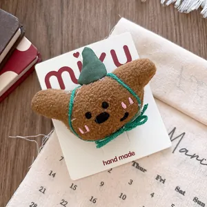 Macro detail of a plush croissant hair clip with a green hat on a display card