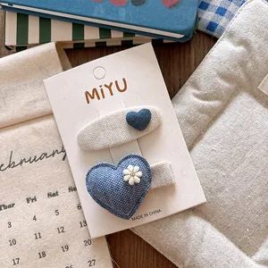 Close-up of blue fabric heart hair clips for girls set on a decorative display card