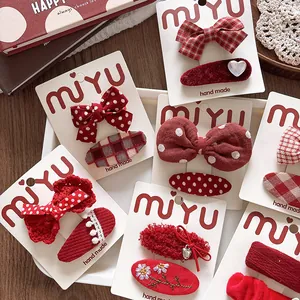 Detailed macro view of handmade red fabric bow hair clips for girls with festive patterns