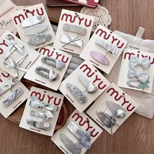 Assortment of handmade silver bow and star hair clips set on display cards